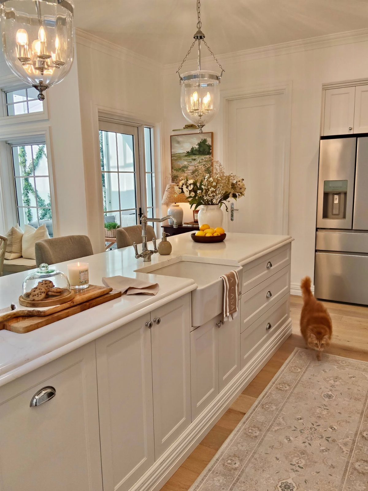22 Apt Kitchen Ideas to Maximize Style and Function 23 White kitchen with a farmhouse sink and a patterned runner rug on wooden floors.