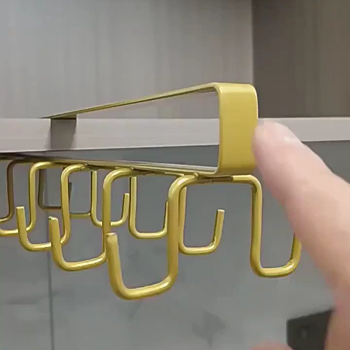 22 Apt Kitchen Ideas to Maximize Style and Function 20 Gold metal under-shelf hook rack being installed on a gray kitchen shelf.