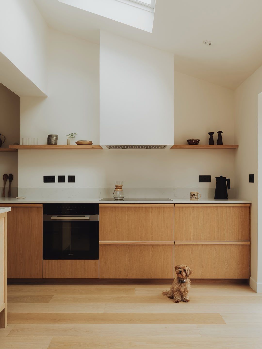 22 Apt Kitchen Ideas to Maximize Style and Function 3 Modern kitchen with light wood cabinets and floating wall shelves holding minimalist decor.