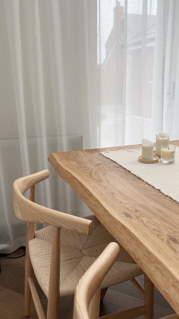 Light ash wood dining chair with woven seat next to a live-edge table