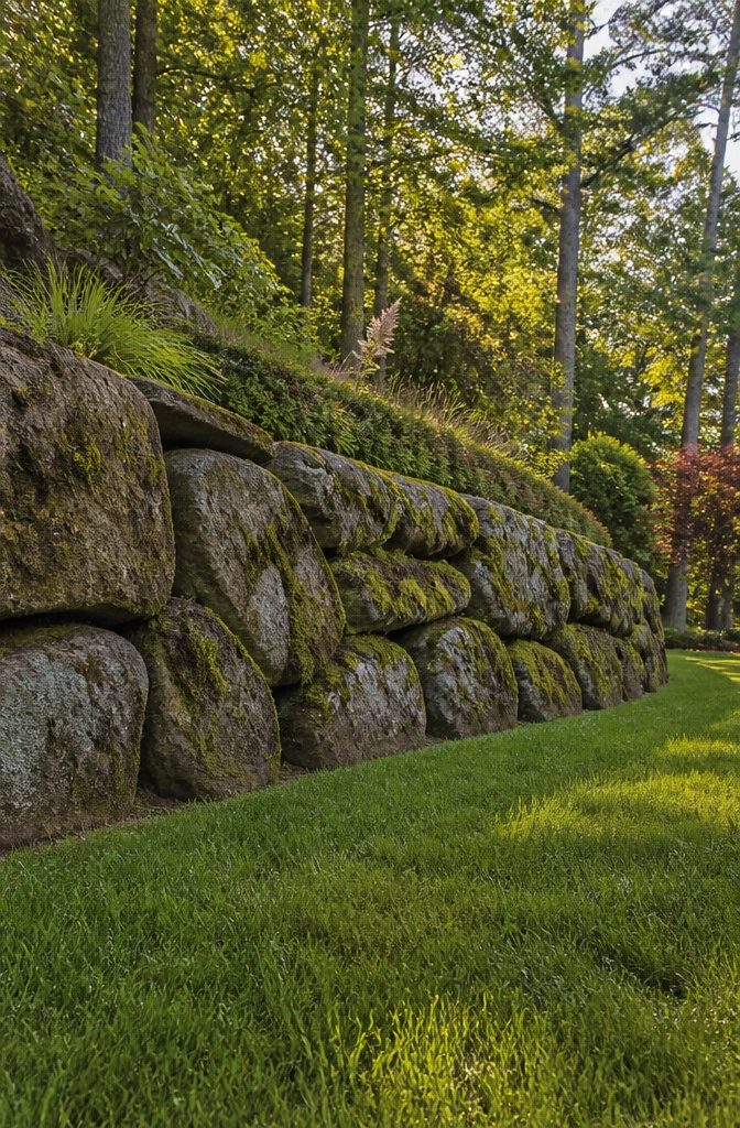 Moss rock retaining wall with a weathered surface and natural moss.