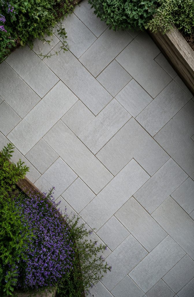 A patio laid in a herringbone pattern using rectangular pavers.