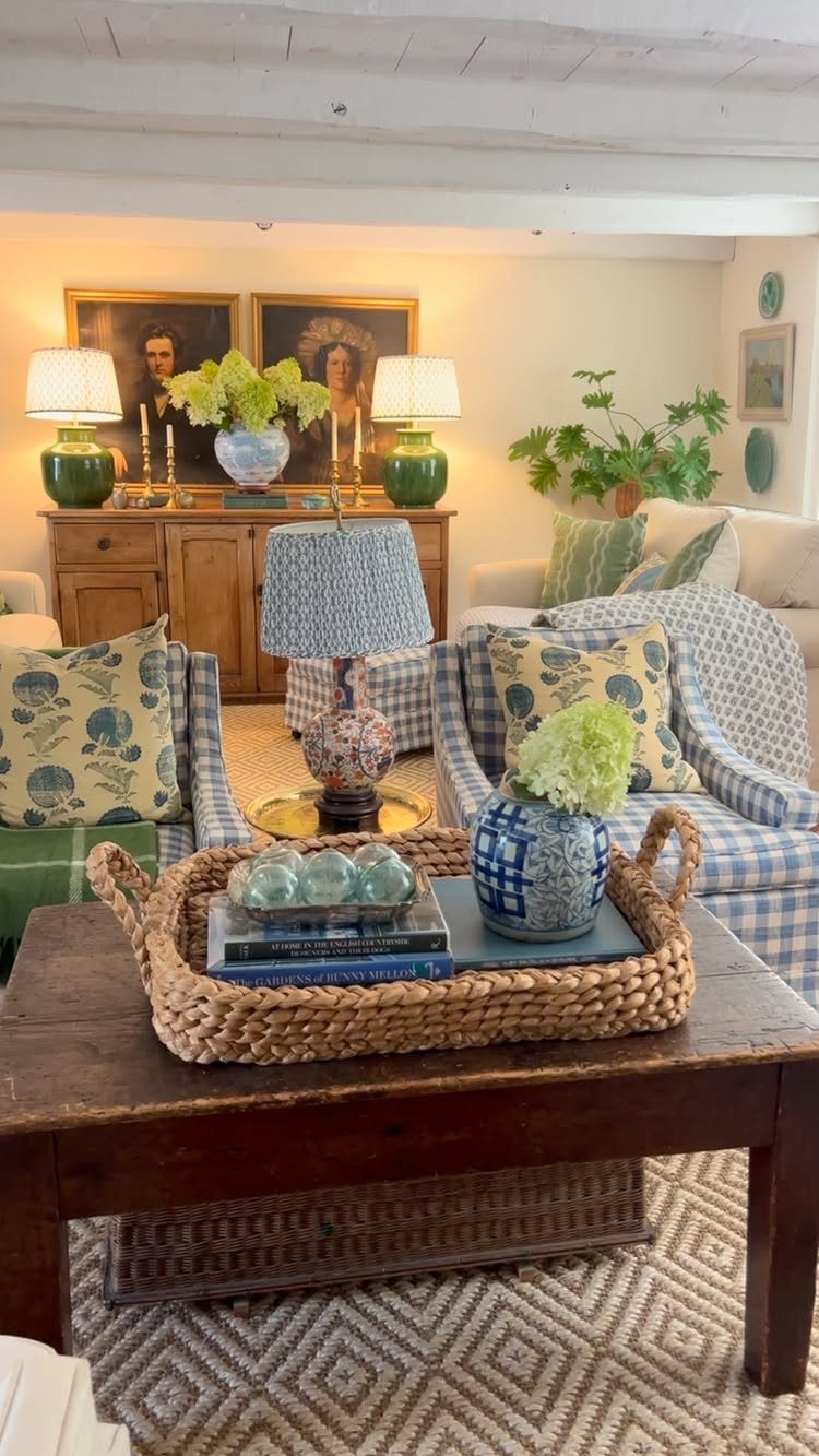 Rustic living room with blue patterned armchairs, wooden coffee table, and beamed ceiling.