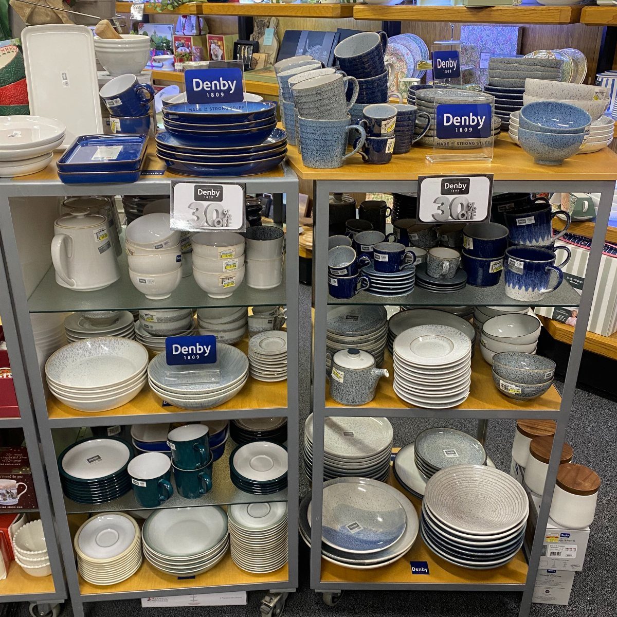Denby Dinnerware Sets in 5 Classic Styles 5 Denby dinnerware sets including blue and grey plates and bowls on store shelves.
