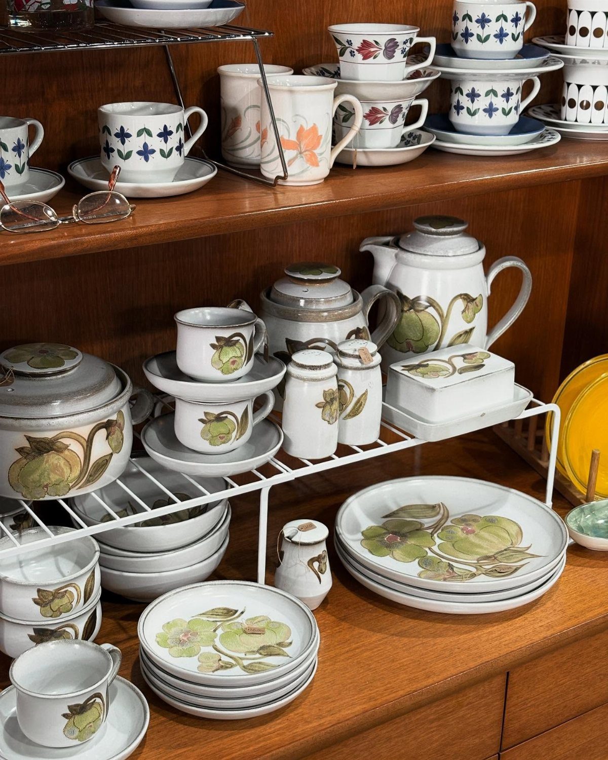 Denby Dinnerware Sets in 5 Classic Styles 2 Vintage Denby stoneware plates and bowls with botanical patterns on wooden shelves.