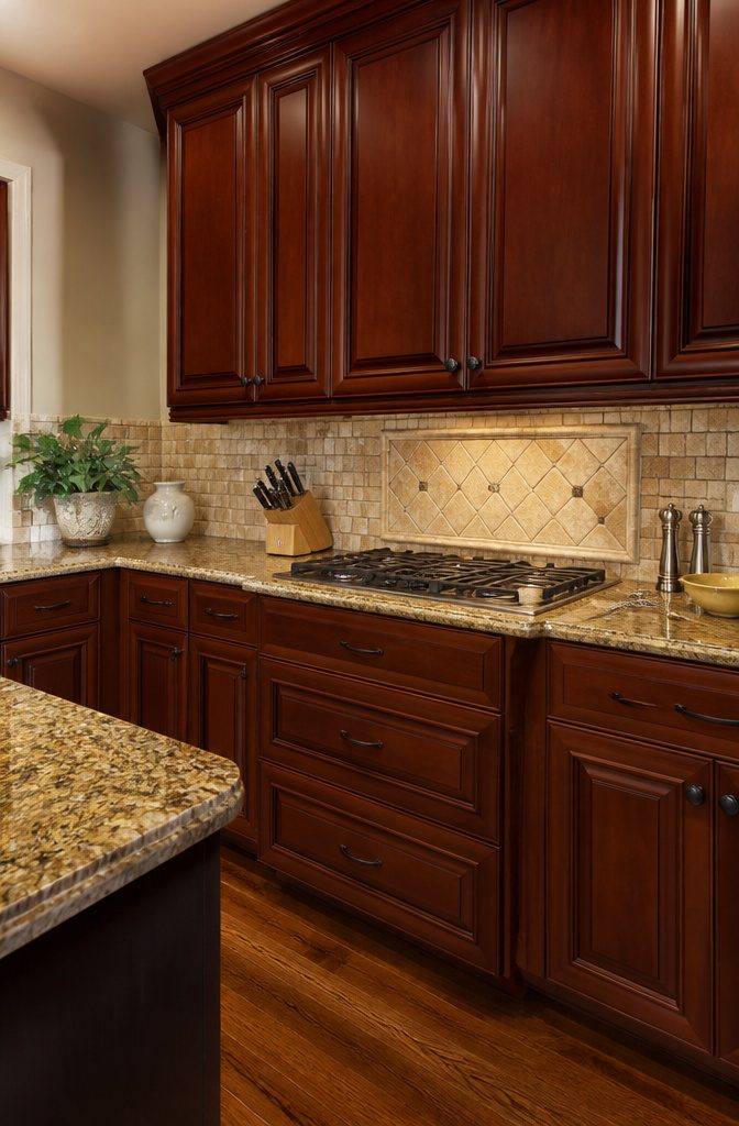 A kitchen with raised panel cabinet doors and a polished countertop.