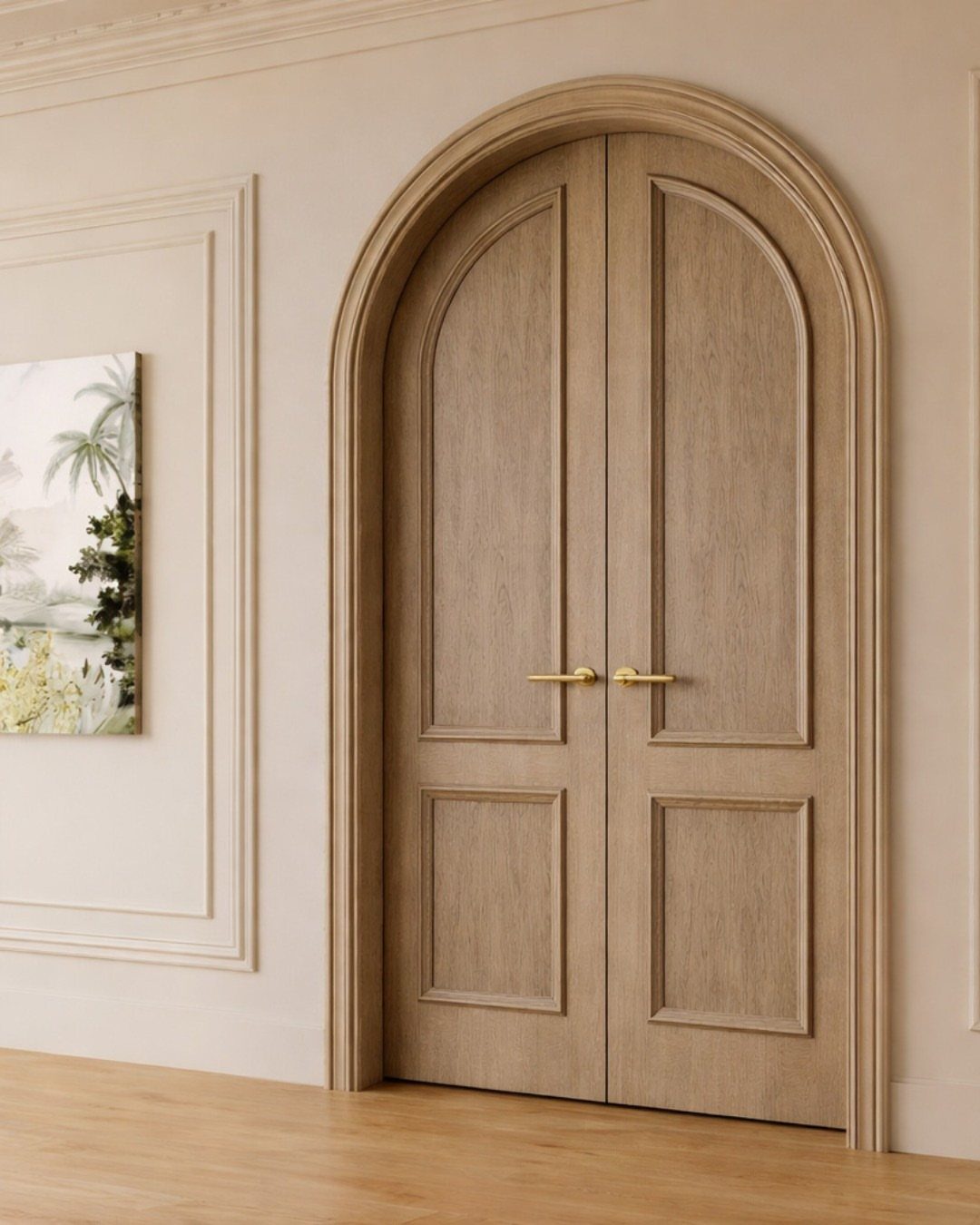 Arched wooden double doors with gold handles in a neutral room with wall molding.