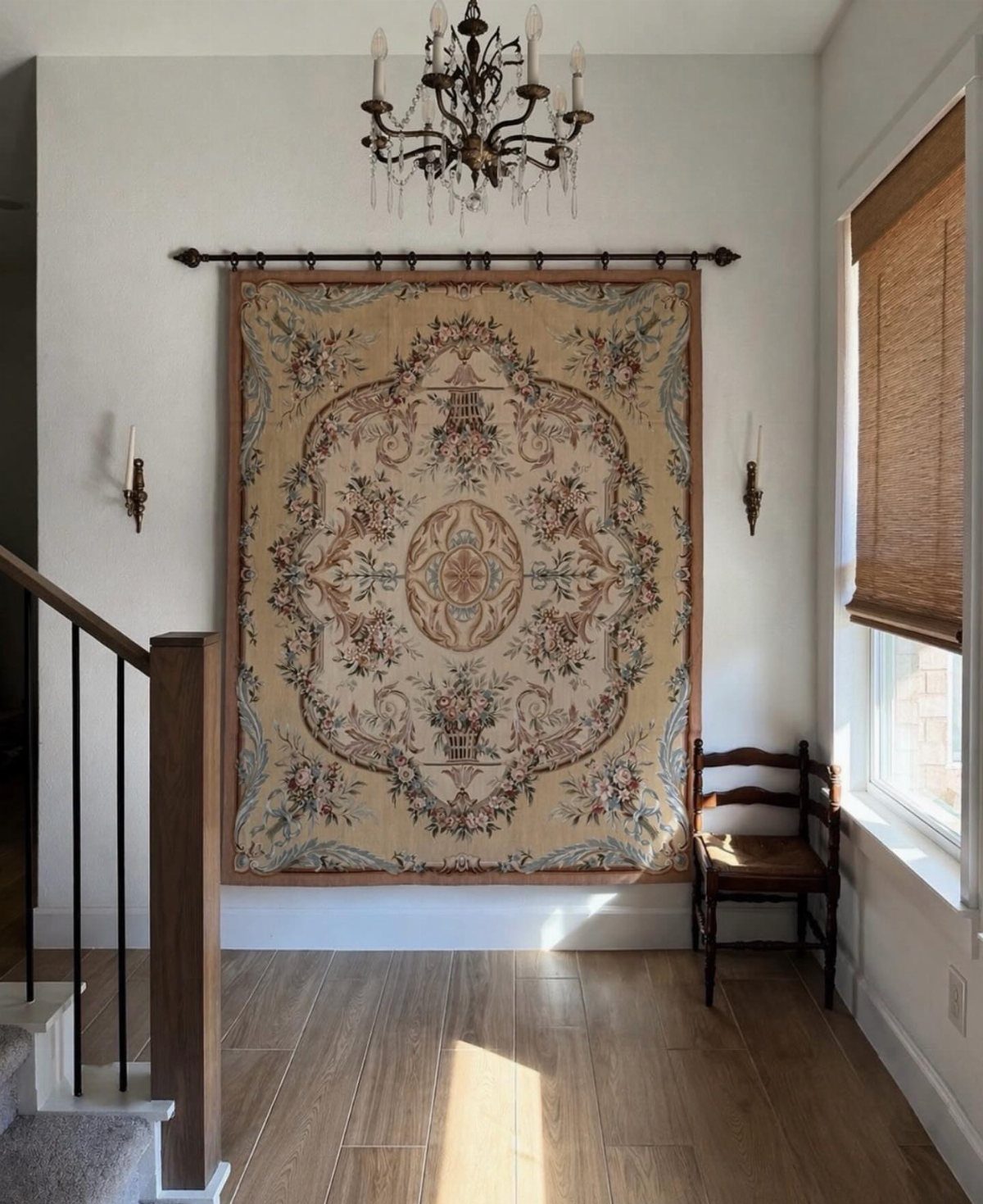 Ornate Aubusson rug hanging on a white wall in a classic European interior.