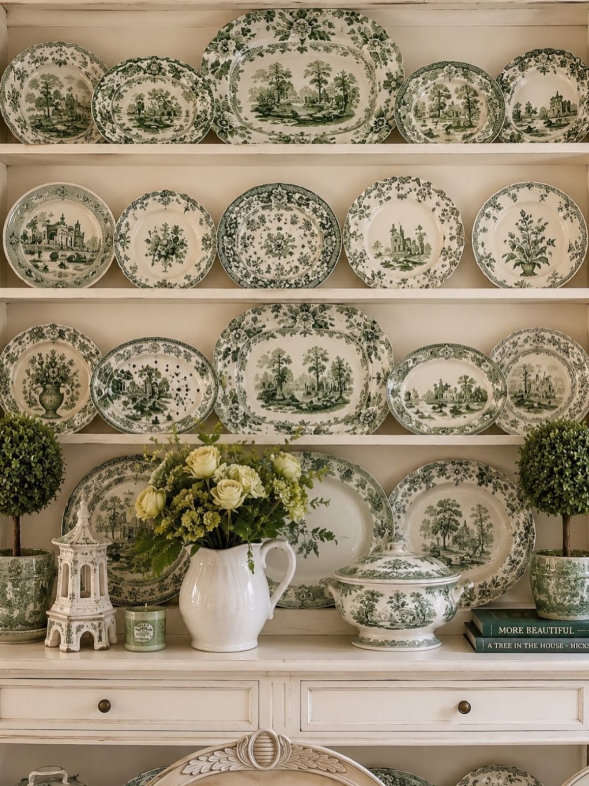 Collection of green and white toileware plates displayed on white wooden shelves.