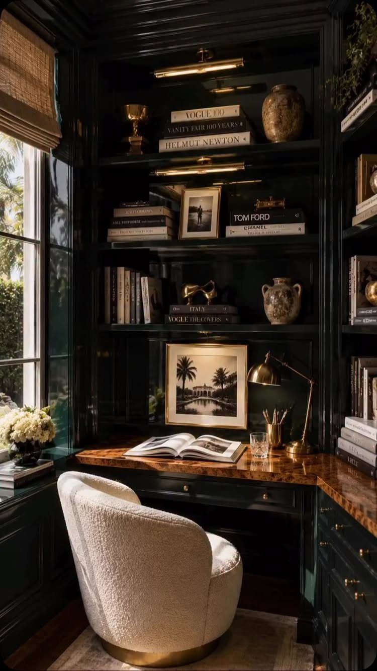 Dark green built-in bookshelves and wooden desk with a white textured swivel chair.