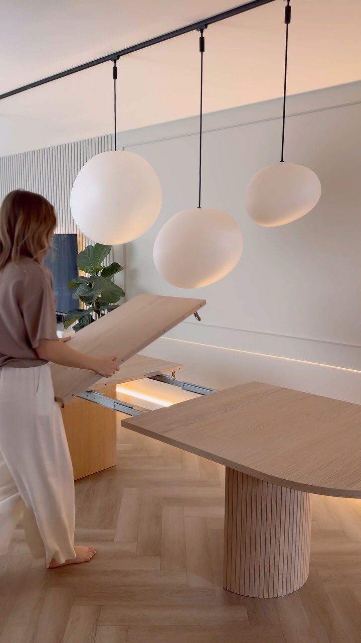 Extendable Kitchen Table Designs: 16 Ideas with Photos 15 Person extending a light wood table with a cylindrical pedestal base in a modern room.