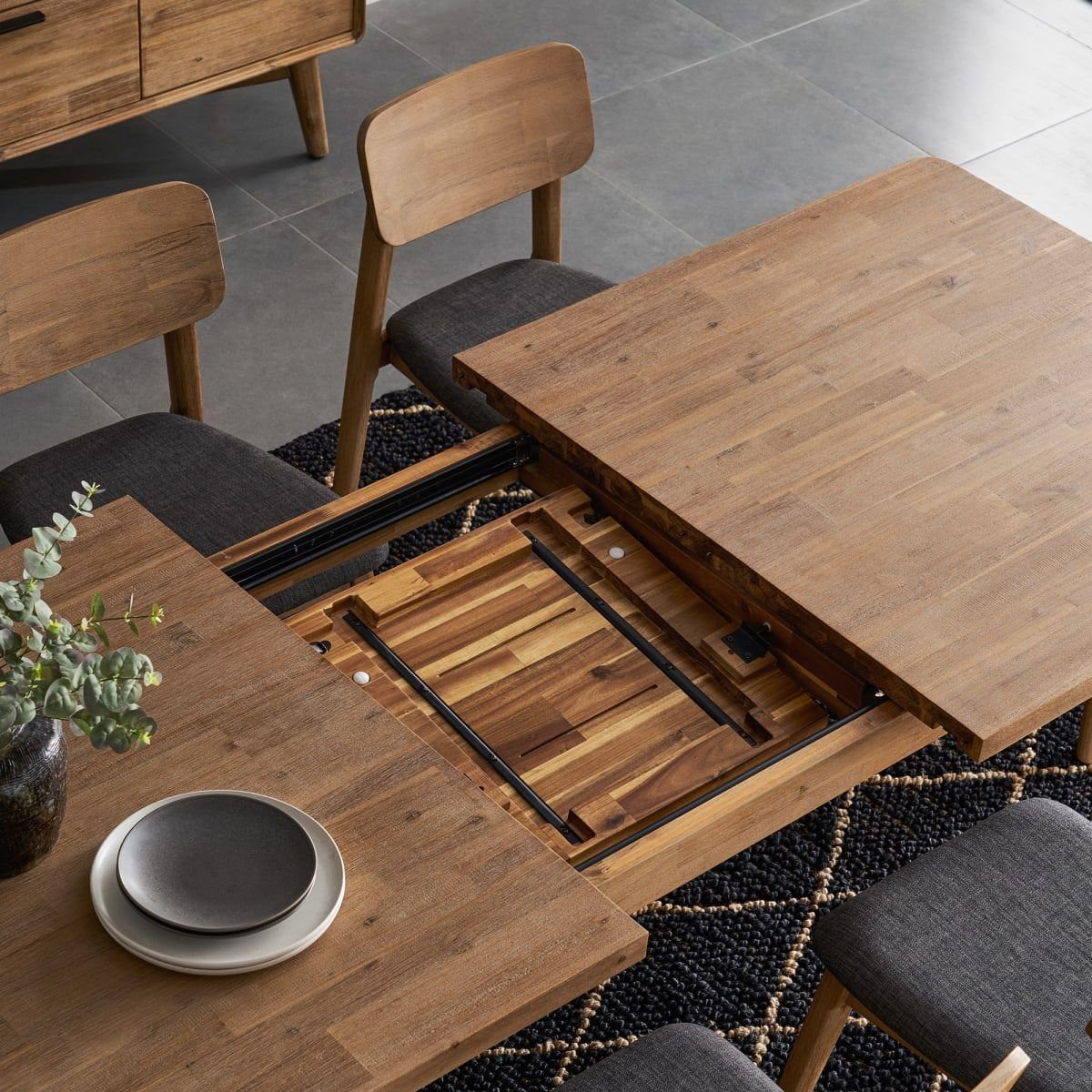 Extendable Kitchen Table Designs: 16 Ideas with Photos 2 Wooden dining table with a sliding leaf mechanism partially extended in a modern room.