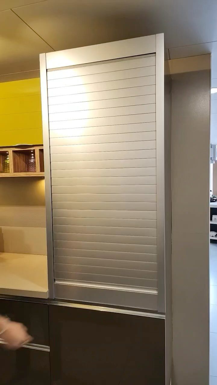 Silver tambour rolling door on a tall kitchen appliance garage cabinet