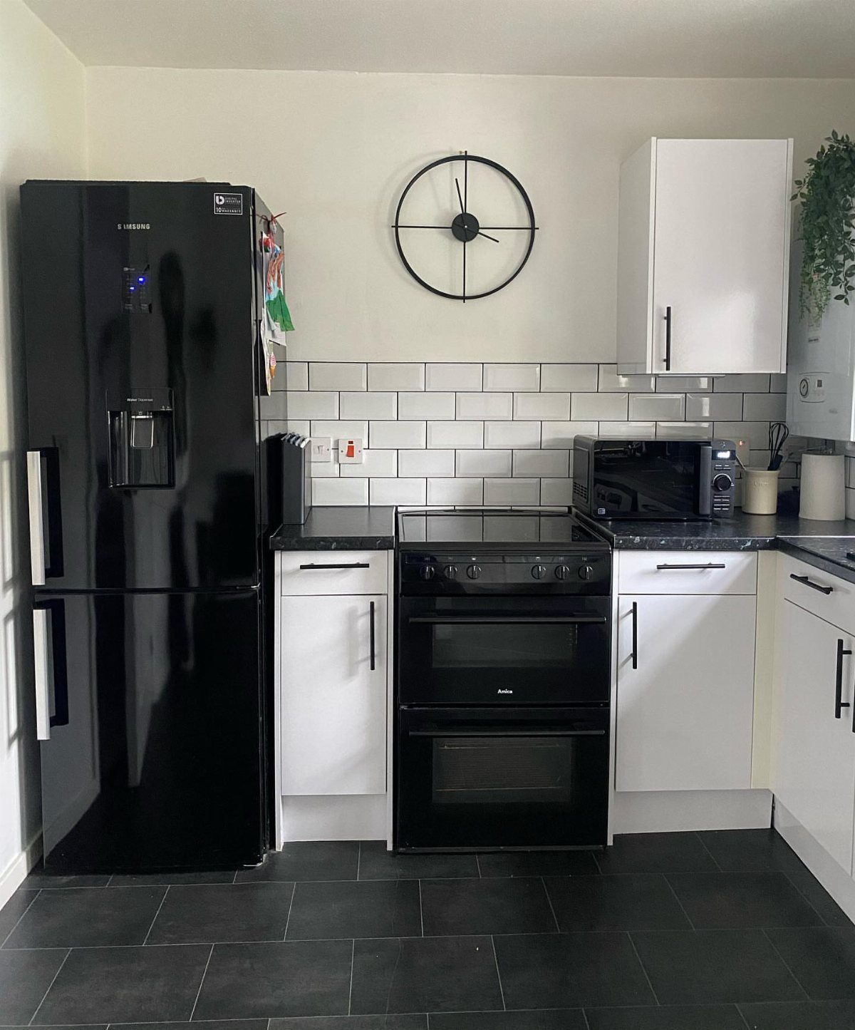 Small kitchen with a black and white monochromatic color scheme and subway tiles.