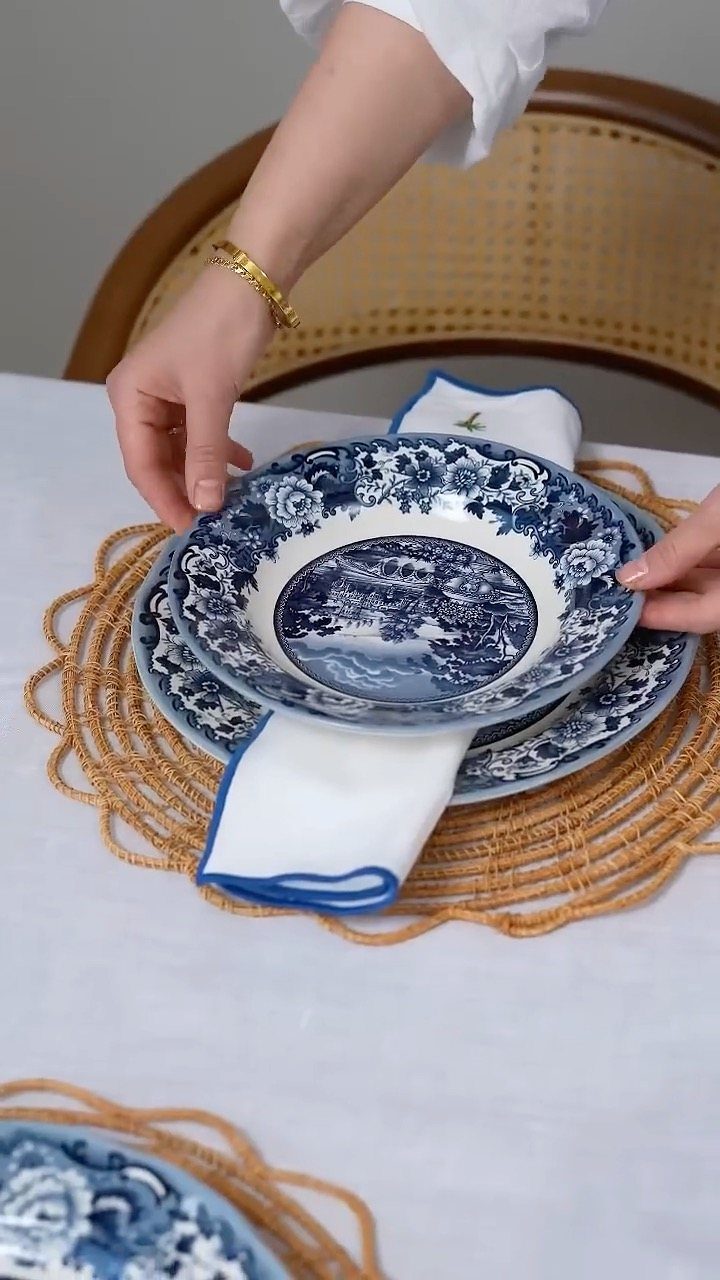 Fancy Dinnerware Set Ideas for 2026 Tables (28 Styles) 14 Blue and white patterned ceramic dinnerware set on a woven rattan charger.