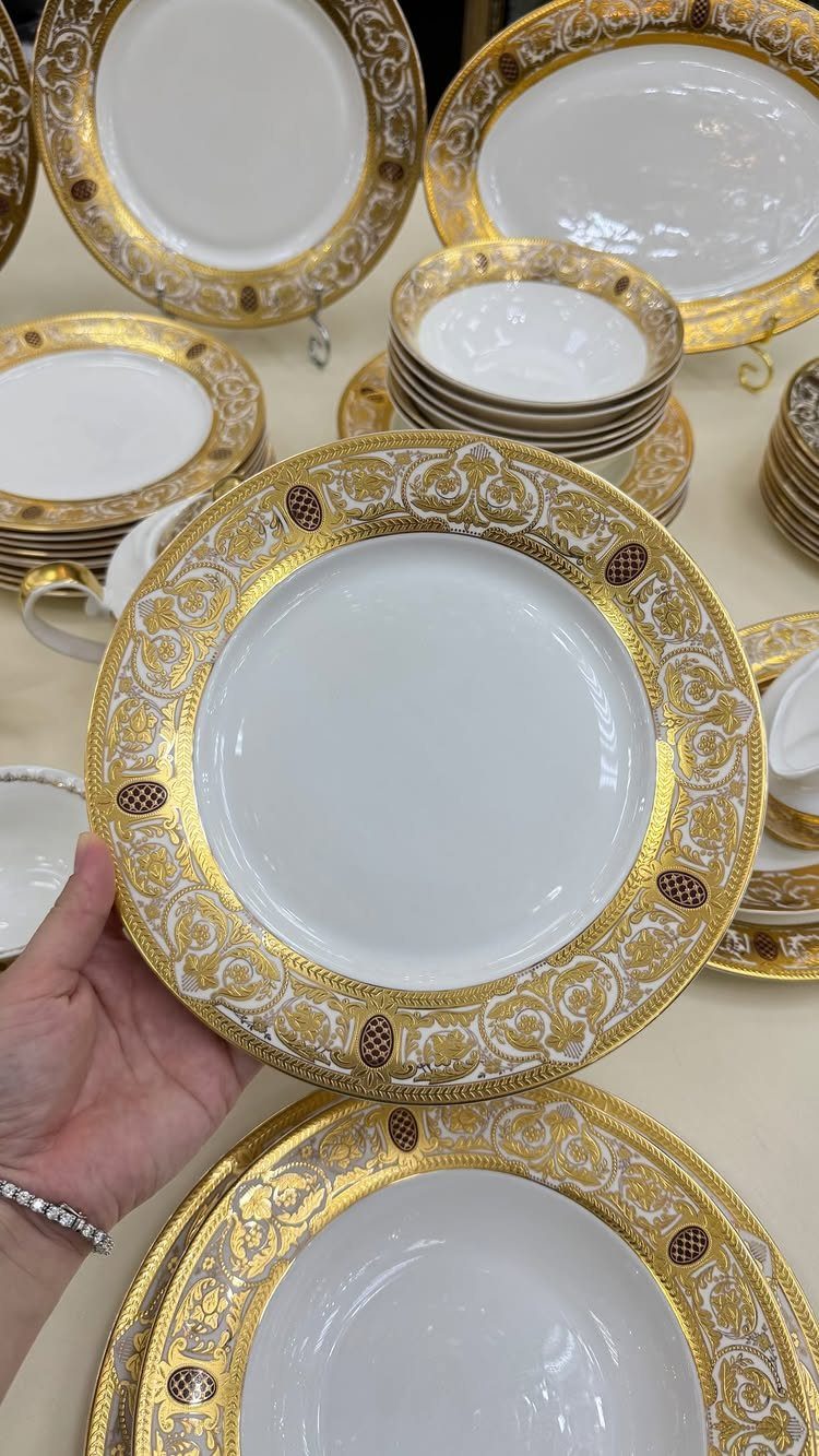 Fancy Dinnerware Set Ideas for 2026 Tables (28 Styles) 27 Ornate white and gold dinnerware set with decorative filigree borders on a table