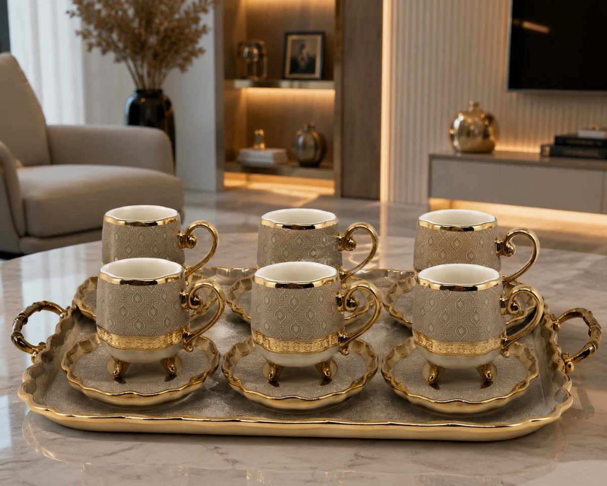 Fancy Dinnerware Set Ideas for 2026 Tables (28 Styles) 7 Ornate grey and gold coffee cups on saucers arranged on a gold tray.