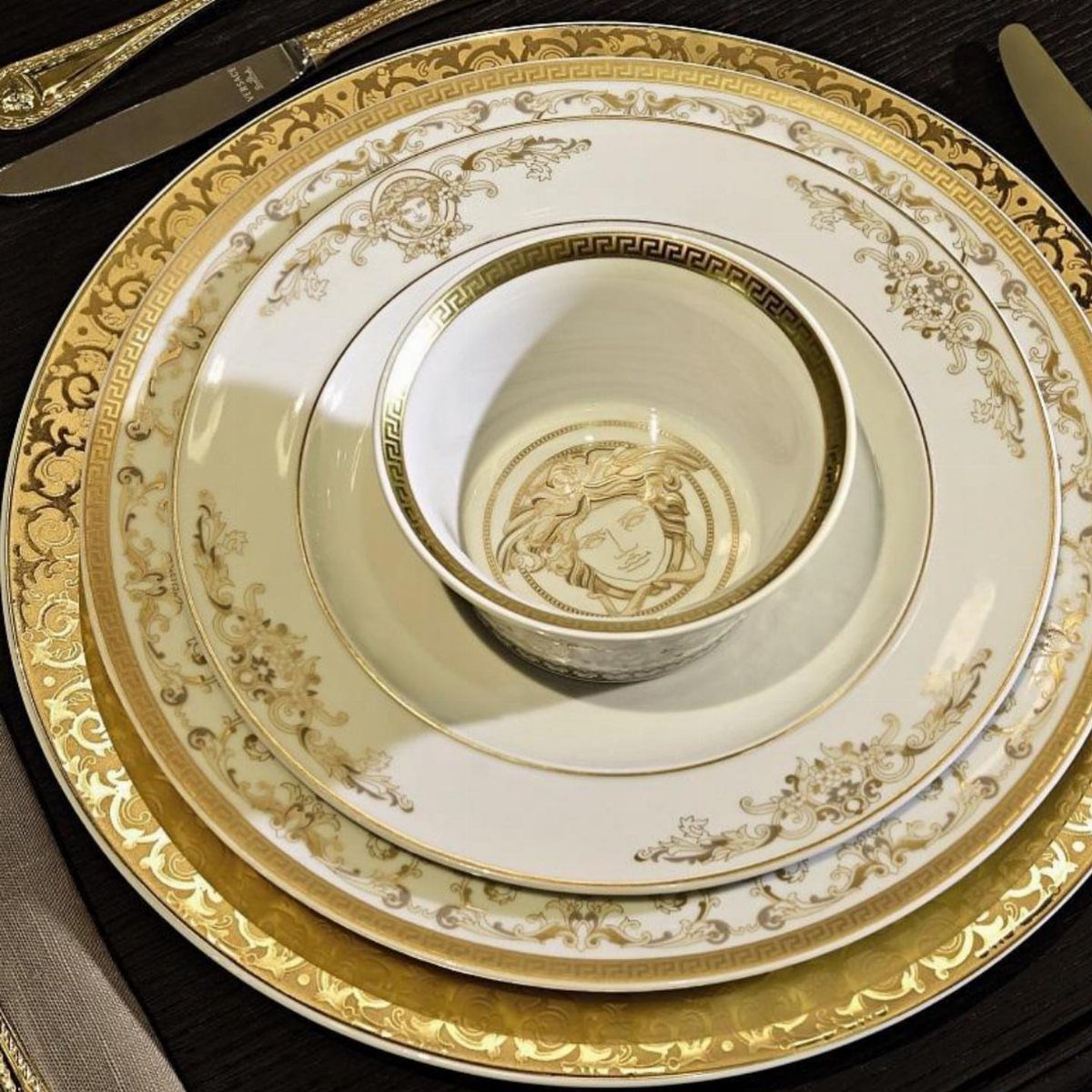 Fancy Dinnerware Set Ideas for 2026 Tables (28 Styles) 13 Stacked white porcelain dinnerware with ornate gold Greek key patterns and classical figures.