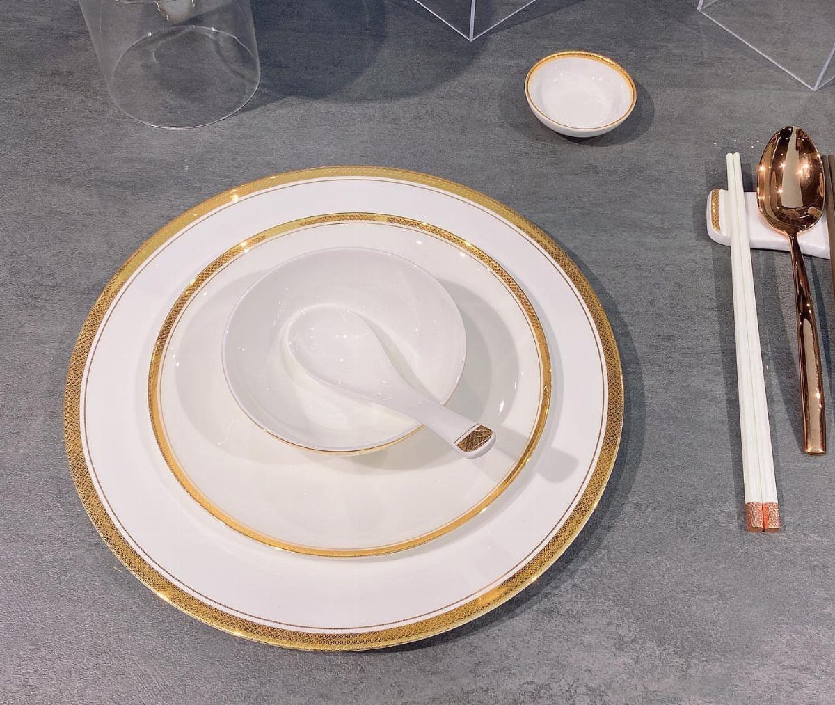 Fancy Dinnerware Set Ideas for 2026 Tables (28 Styles) 19 White dinnerware set with gold rims and matching spoon on grey surface.