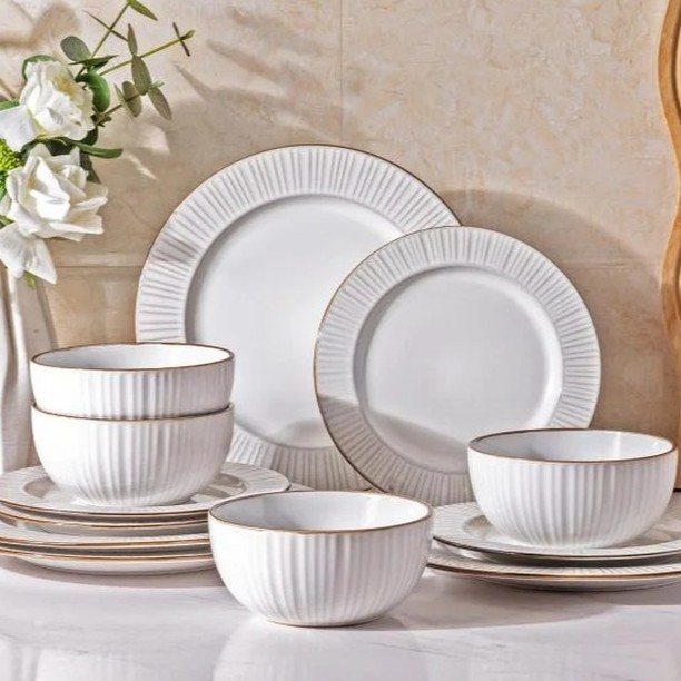 Fancy Dinnerware Set Ideas for 2026 Tables (28 Styles) 12 White ribbed ceramic dinnerware set with gold rims on a marble surface.
