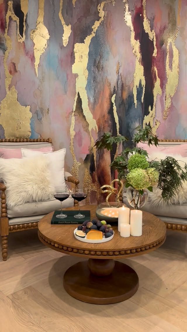 9 Gold Accent Living Room Ideas for Every Style 6 Living room with a round wooden table and abstract gold leaf wall art.