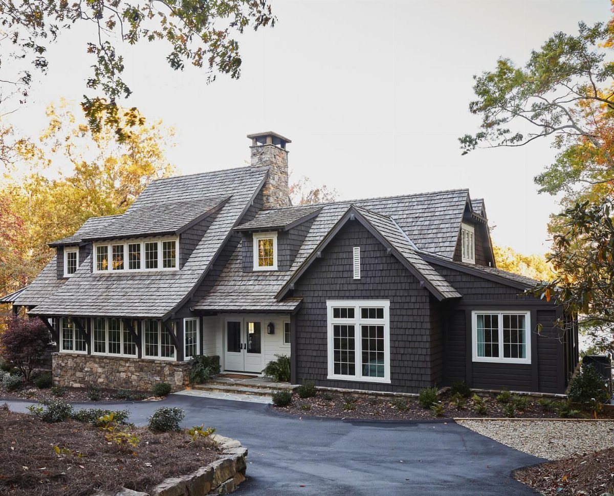 Dark gray house with cedar shingle siding, white trim, and a stone chimney.
