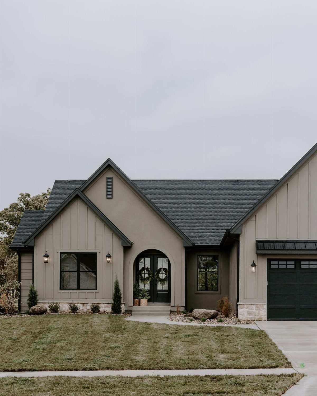 Modern house exterior featuring a mix of vertical siding, stucco, and stone accents.