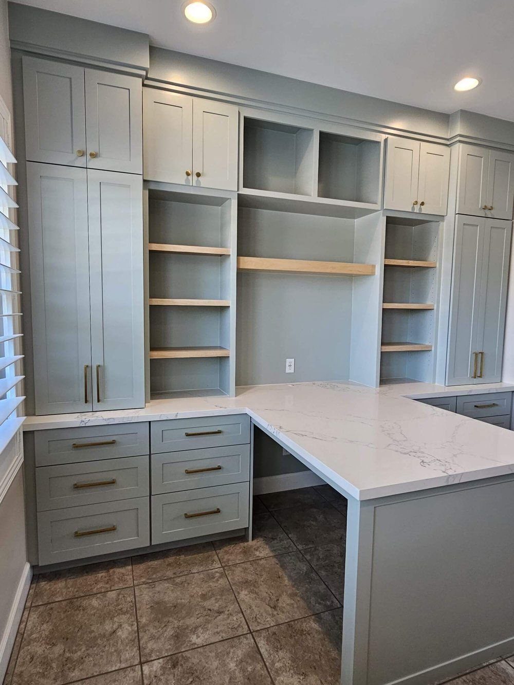 Grey modular cabinets with custom trim and white marble countertops in a home office.