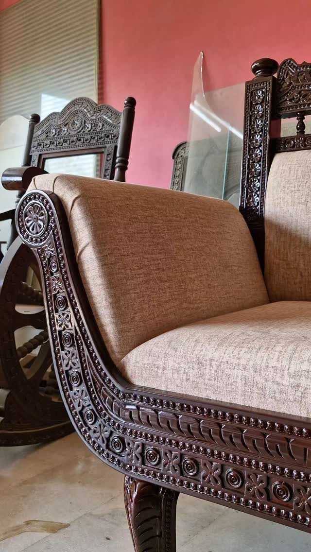 Indian Room Decor: 37 Ideas From Textiles to Wall Hangings 15 Intricately carved dark brown wooden sofa armrest with beige fabric upholstery against pink wall.