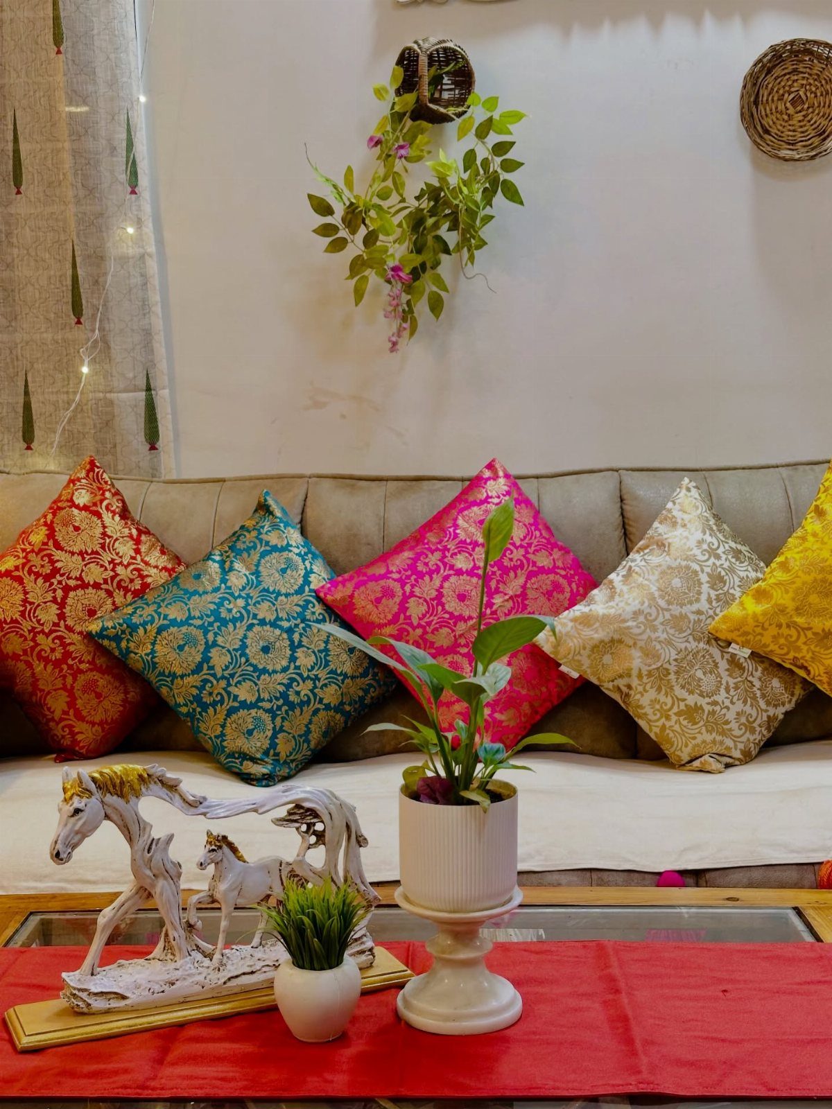 Indian Room Decor: 37 Ideas From Textiles to Wall Hangings 7 Colorful patterned silk cushions on a beige sofa with a red table runner.