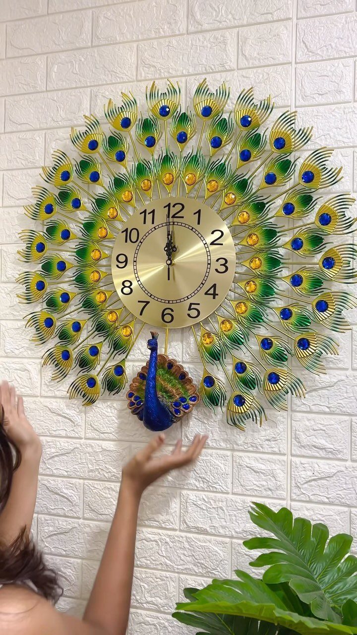 Indian Room Decor: 37 Ideas From Textiles to Wall Hangings 35 Peacock shaped wall clock with colorful feathers on a white brick wall