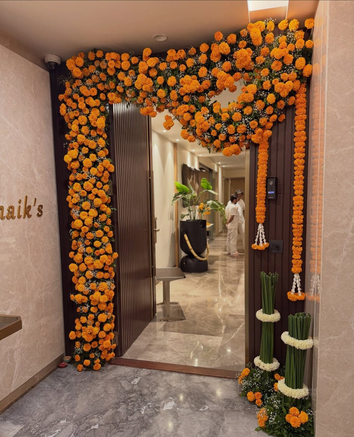 Indian Room Decor: 37 Ideas From Textiles to Wall Hangings 24 Doorway decorated with thick garlands of bright orange marigold flowers and white accents.