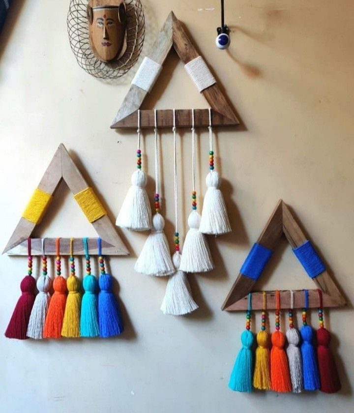 Indian Room Decor: 37 Ideas From Textiles to Wall Hangings 30 Three triangular wooden wall hangings wrapped in colorful yarn with hanging tassels.