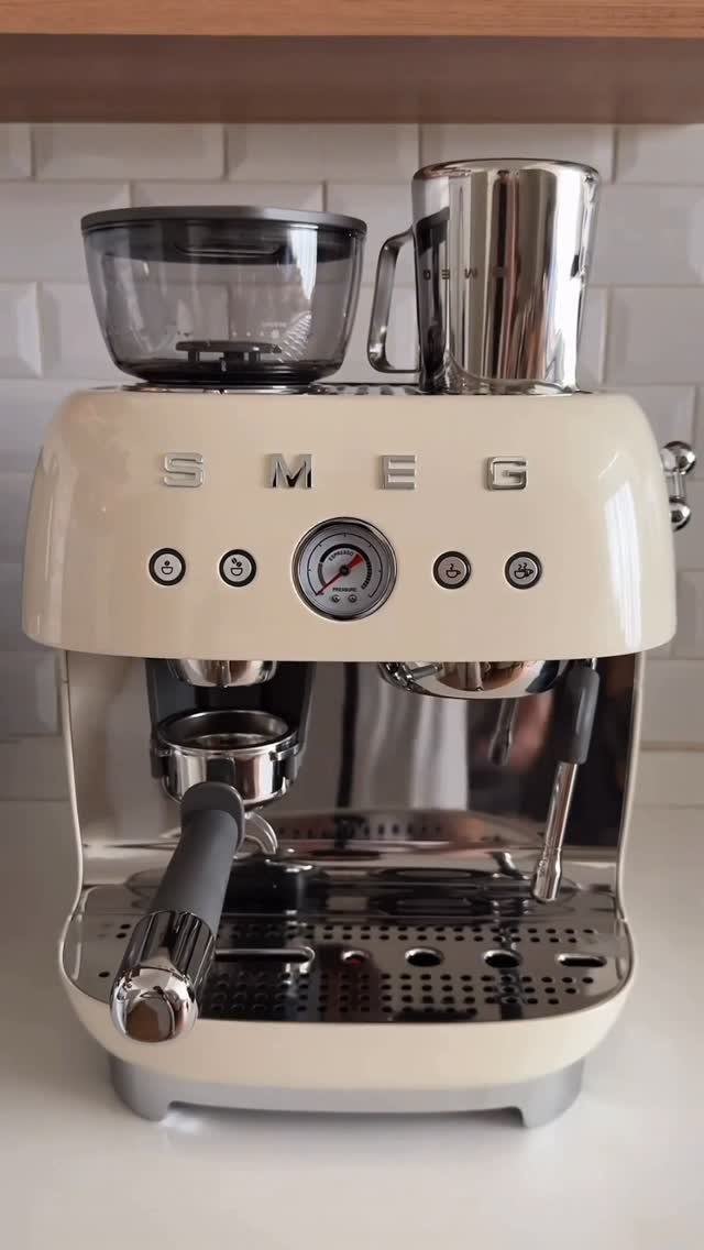 14 Kitchen Tabletop Decor Ideas to Style Your Counters 5 Cream Smeg espresso machine with milk pitcher on a white kitchen counter.