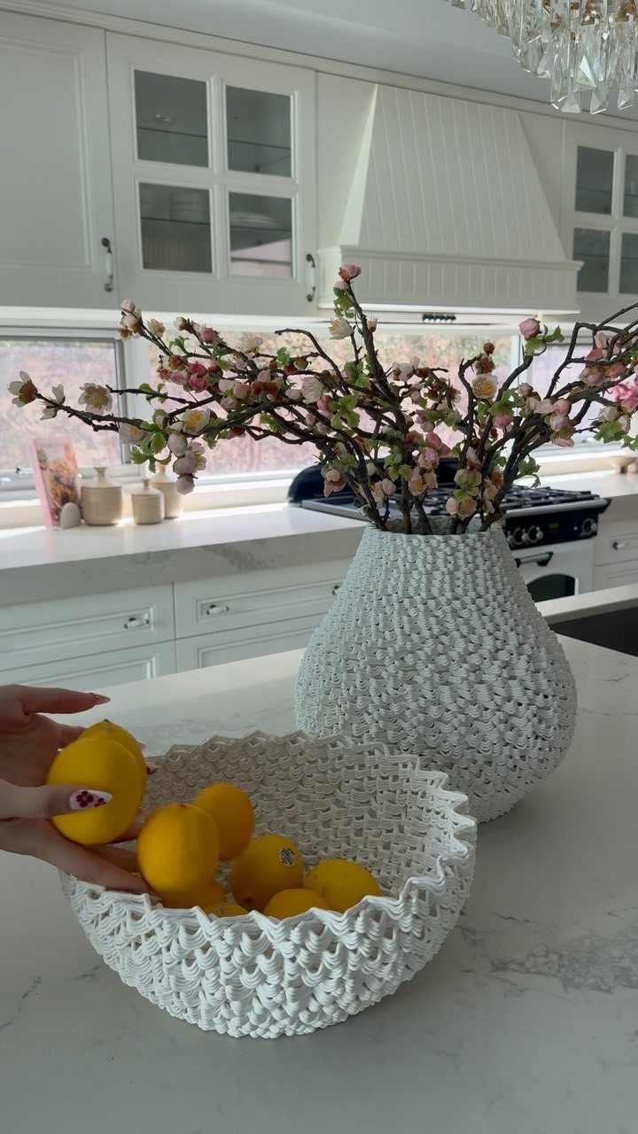 14 Kitchen Tabletop Decor Ideas to Style Your Counters 3 White crocheted bowl of yellow lemons and a matching vase with pink blossoms.