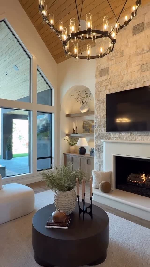 Stone fireplace with a mounted TV and built-in cabinets in an arched alcove.