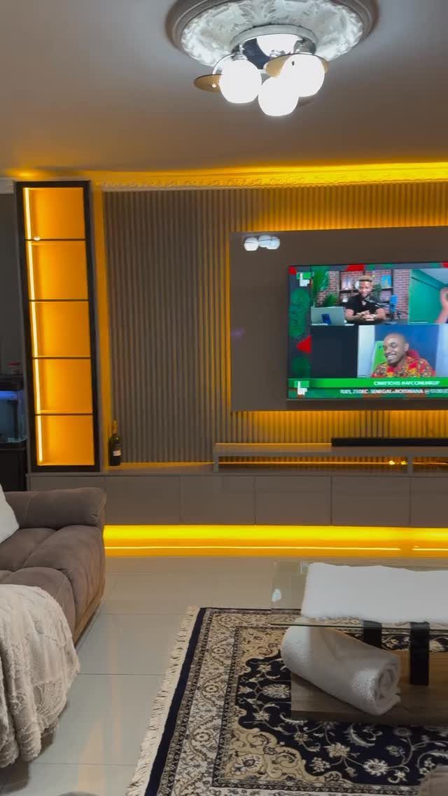 Modern living room with a backlit glass display cabinet and entertainment center.