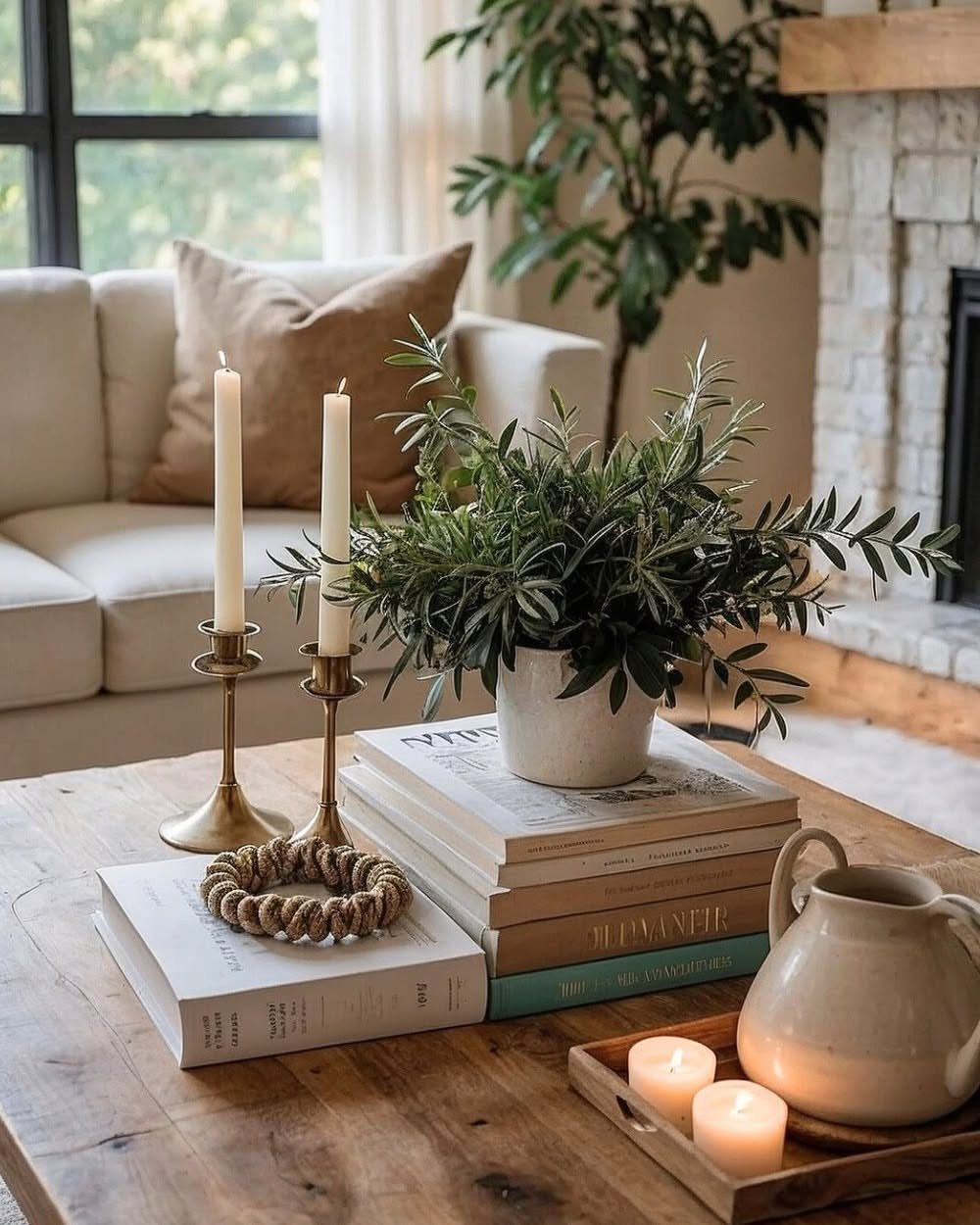 Horizontal book stack on a wooden table supporting a potted green plant.