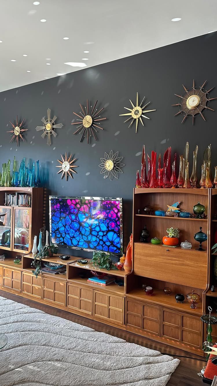 Mid Century Modern Items: 12 Ideas for Your Home 6 Starburst clocks on a dark wall above a mid-century modern wooden console.