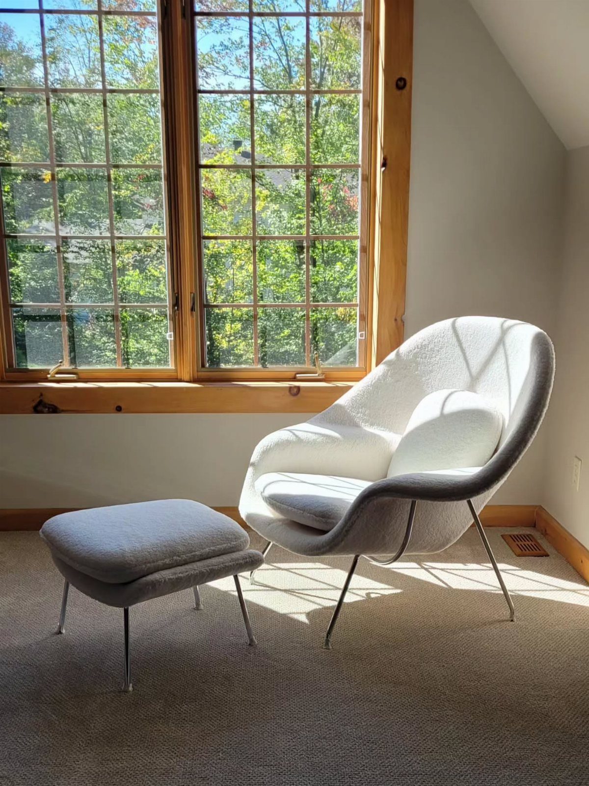 Mid Century Modern Items: 12 Ideas for Your Home 10 White curved mid-century modern lounge chair and ottoman by a large wooden window.