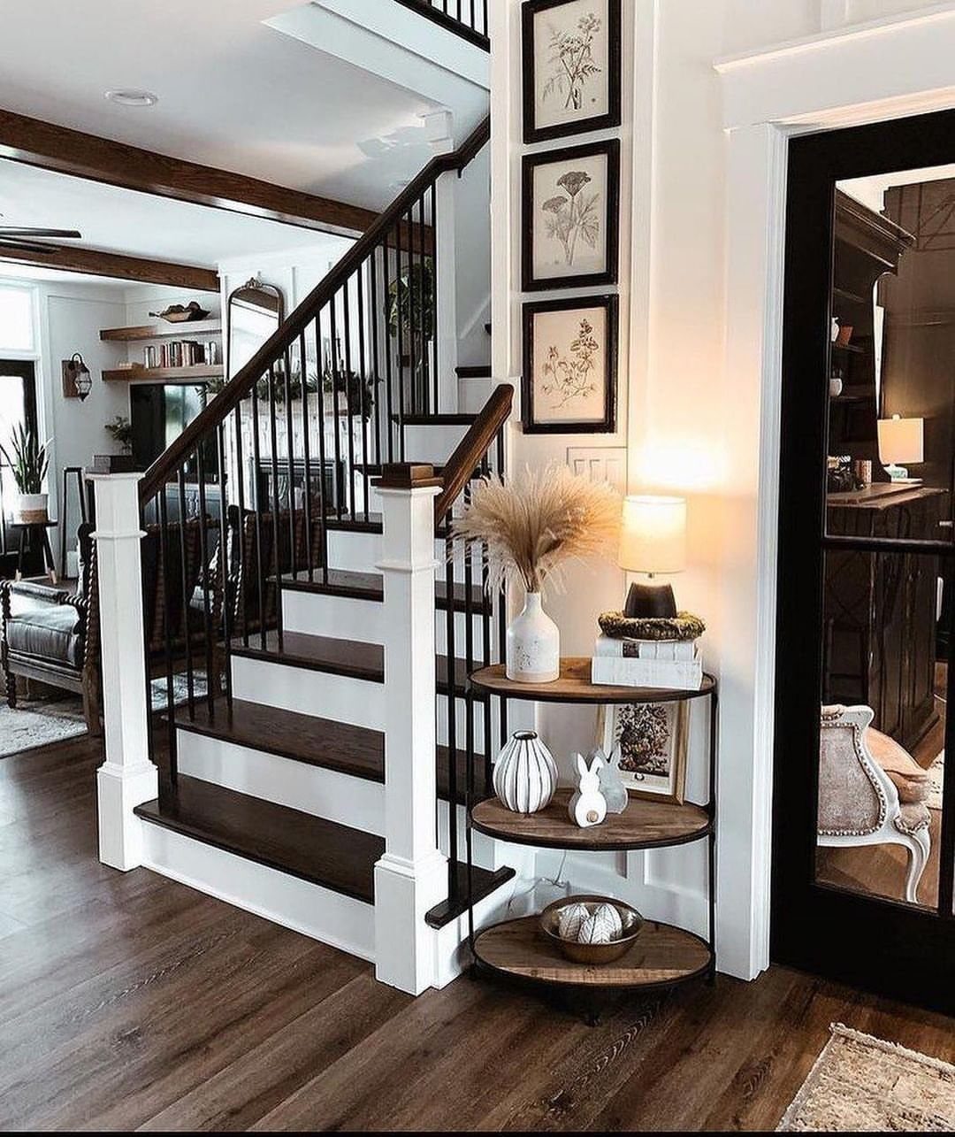 12 Modern Farmhouse Wall Decor Ideas for Living Room 4 Three framed botanical prints hanging vertically on a white wall by a staircase.