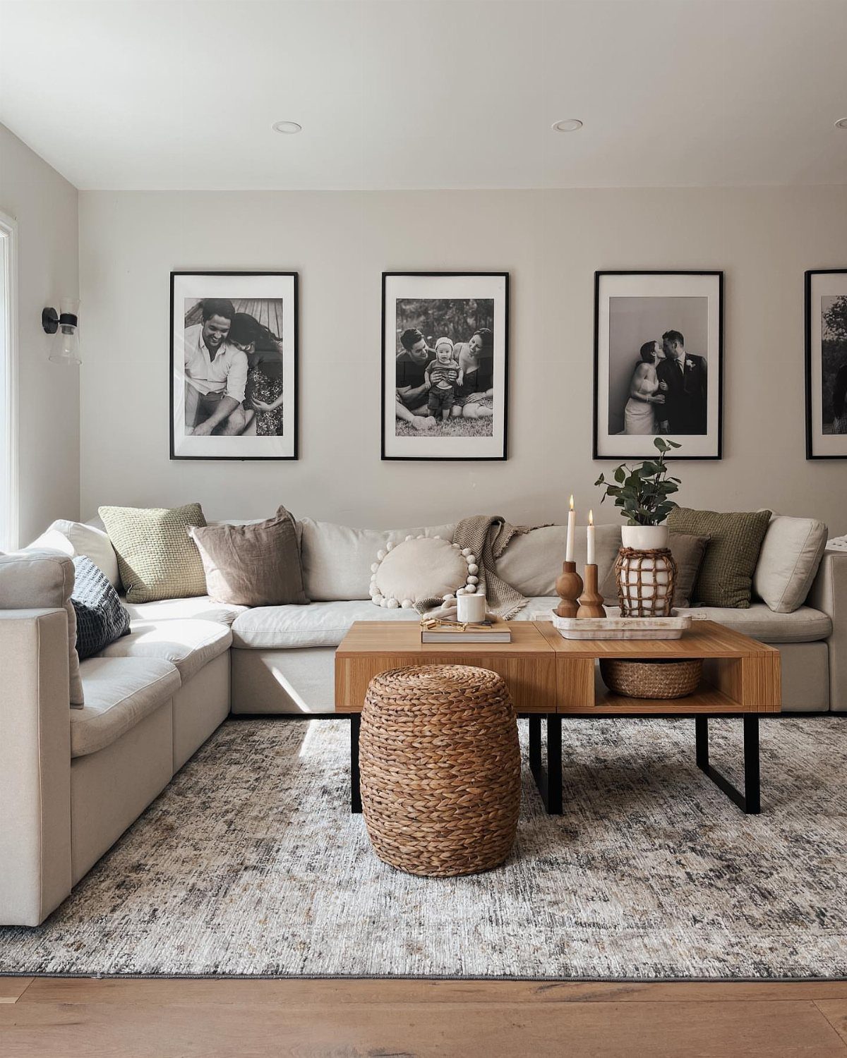 12 Modern Farmhouse Wall Decor Ideas for Living Room 5 Black-framed black-and-white photographs arranged in a row above a white sectional sofa.