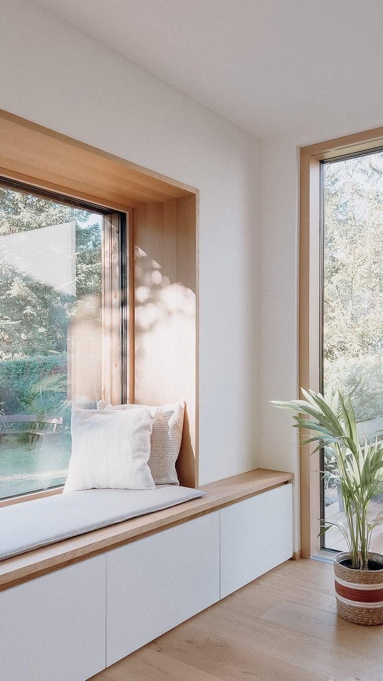 Built-in window seat with white storage drawers underneath and light wood framing.