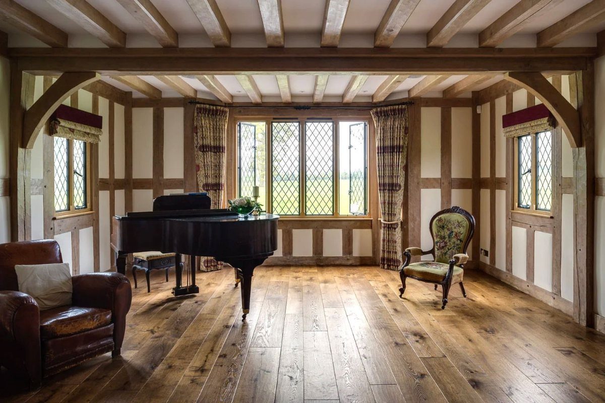 Oak Living Room Ideas: 9 Looks for Floors, Beams, Trim 5 Rustic living room with distressed oak flooring, exposed beams, and a grand piano.