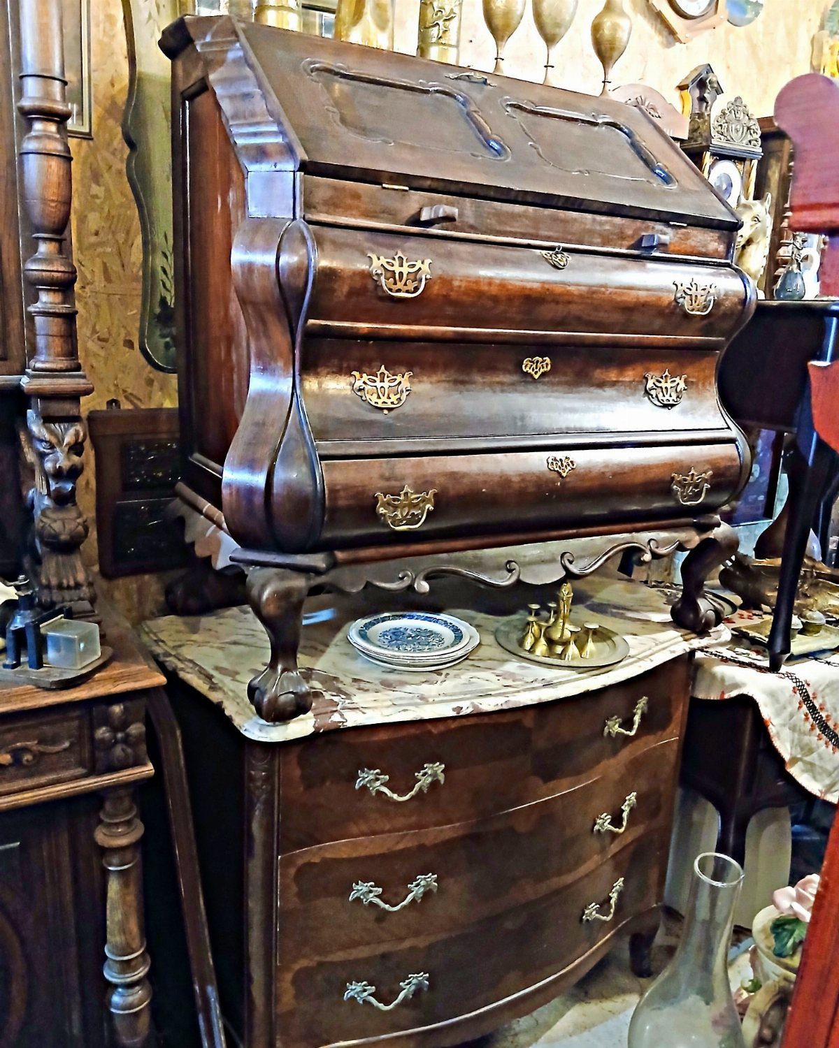Bombe secretary desk with curved drawers and a slant-front top on a marble chest.