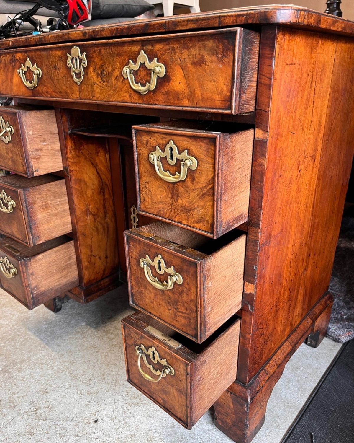 Vintage wooden desk with open drawers and a central kneehole recess for legs.