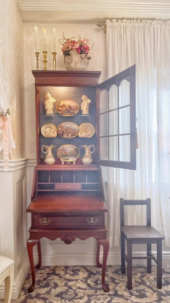 Antique Queen Anne secretary desk with a hutch and cabriole legs in a room.