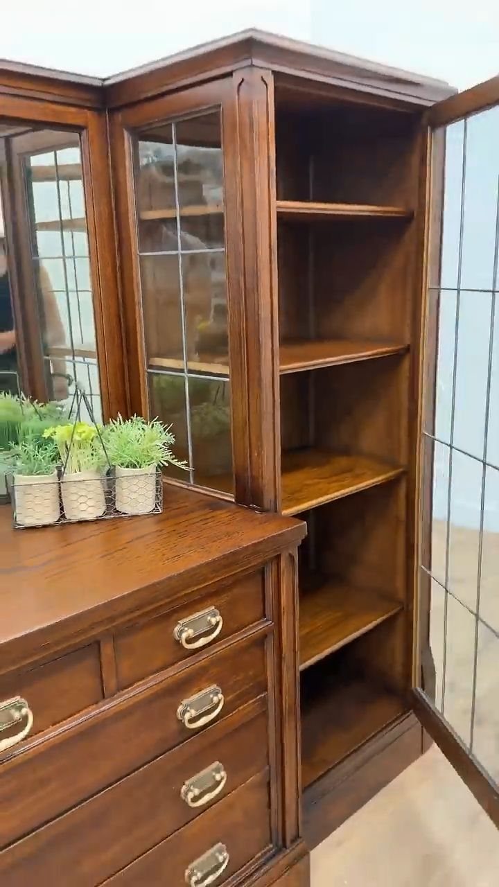 Brown wood hutch with glass doors, open shelves, and a lower dresser unit.