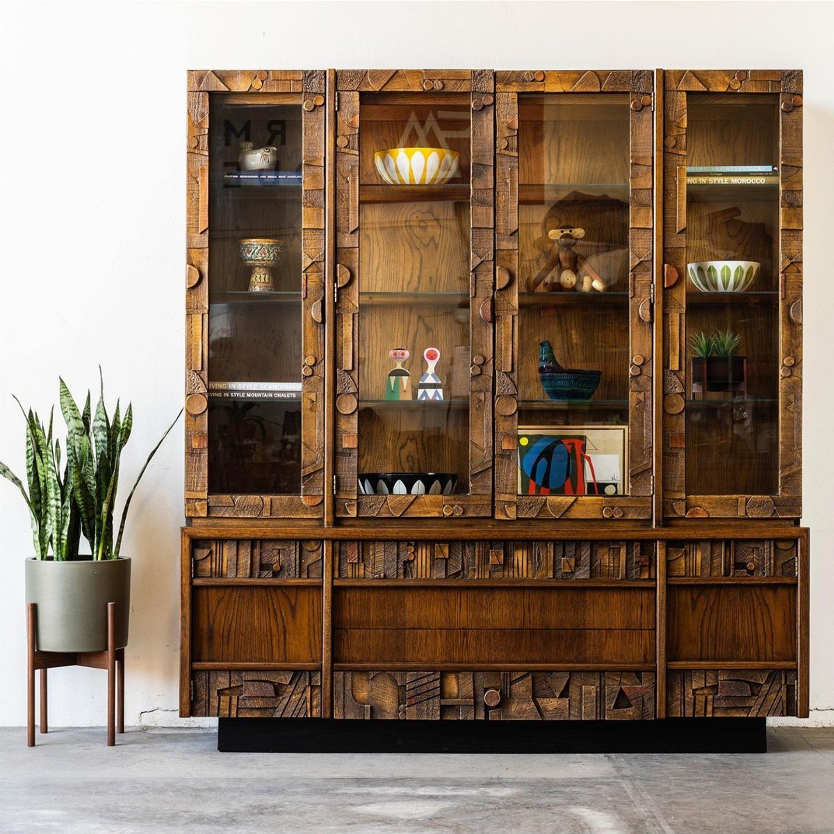 Lane Brutalist hutch with glass display cabinets and a carved geometric wooden base.