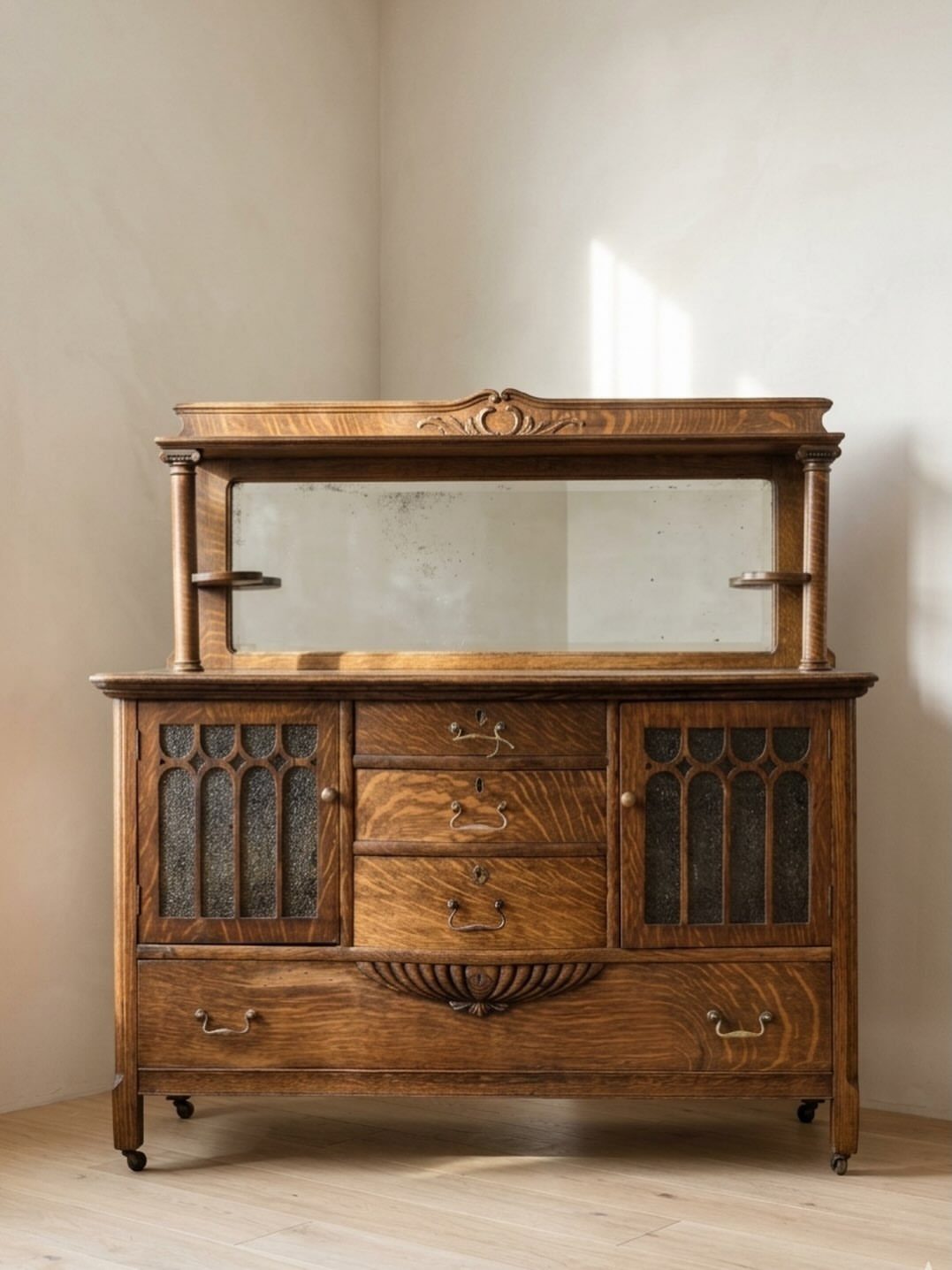 Oak columned buffet hutch with a mirrored back and decorative glass cabinet doors.